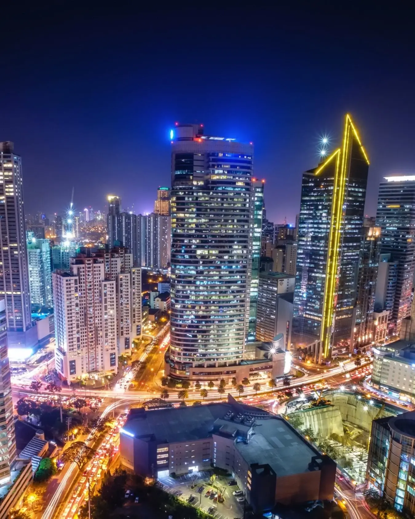 Aerial view of Manila's financial and business district skyline at night, with illuminated skyscrapers and busy roads. Image credit: stock.adobe.com