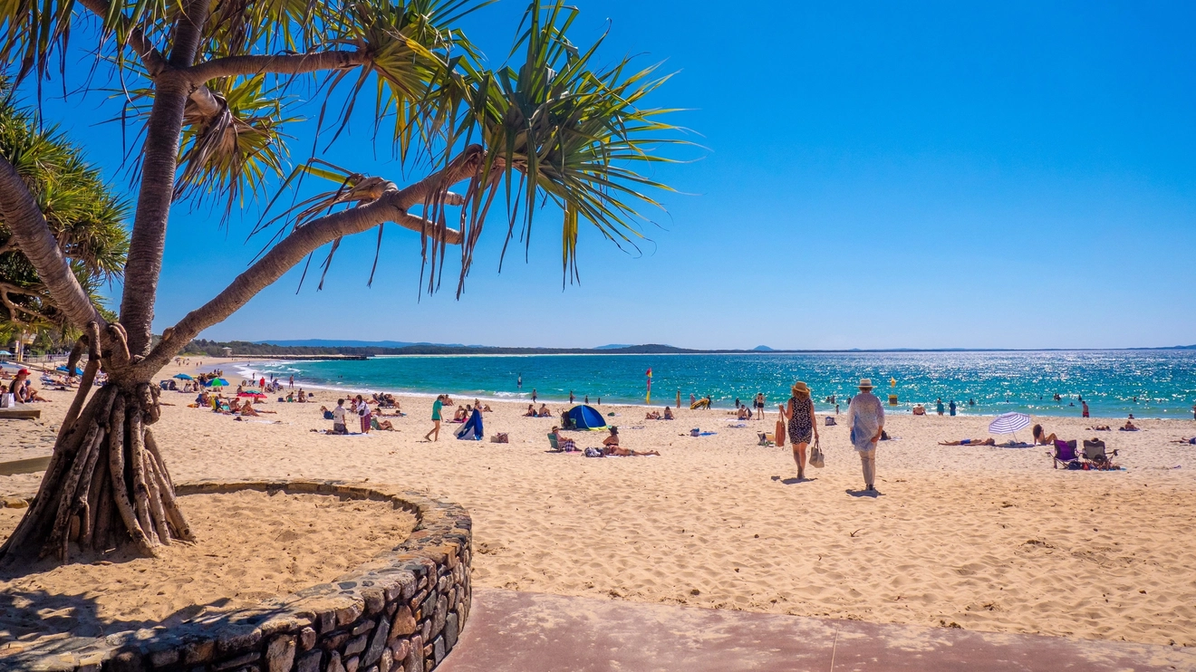 People on the sand at Main Beach, Noosa. Image credit: Tourism and Events Queensland