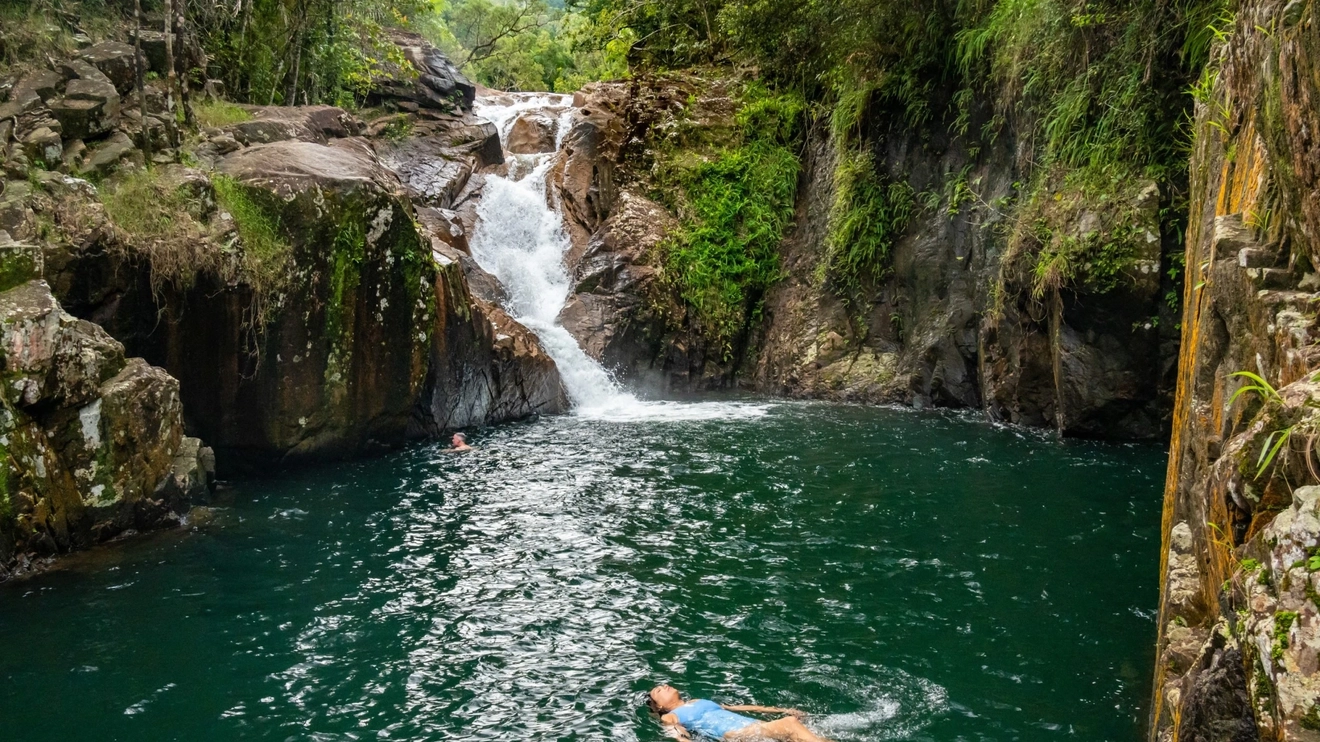 Woman floating in rockpool at Finch Hatton Gorge, Mackay area. Image credit: Tourism and Events Queensland