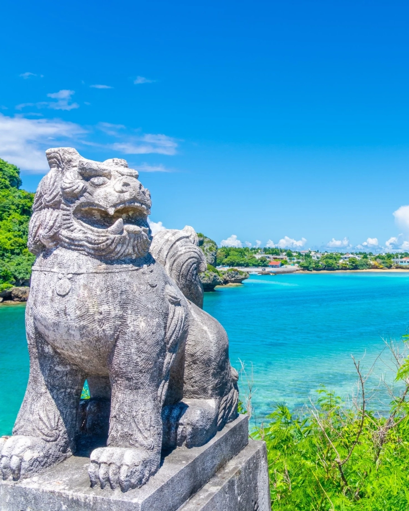 Stone-carved Shisa with Okinawa Sea in the background, Okinawa, Japan. Image credit: stock.aobe.com