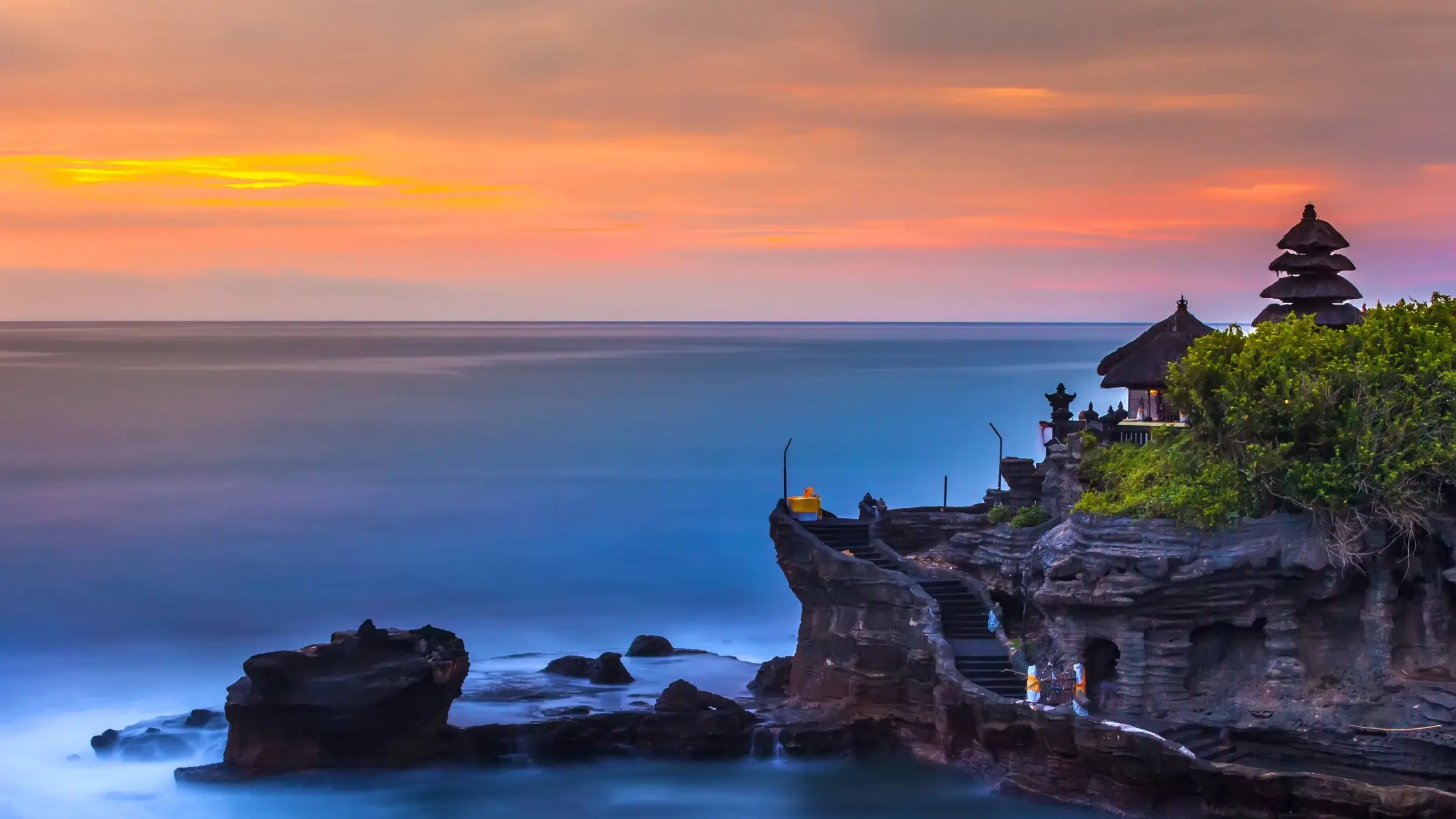 The picturesque Tanah Lot temple, perched on cliffs overlooking the ocean at sunset, Bali. Image credit: stock.adobe.com