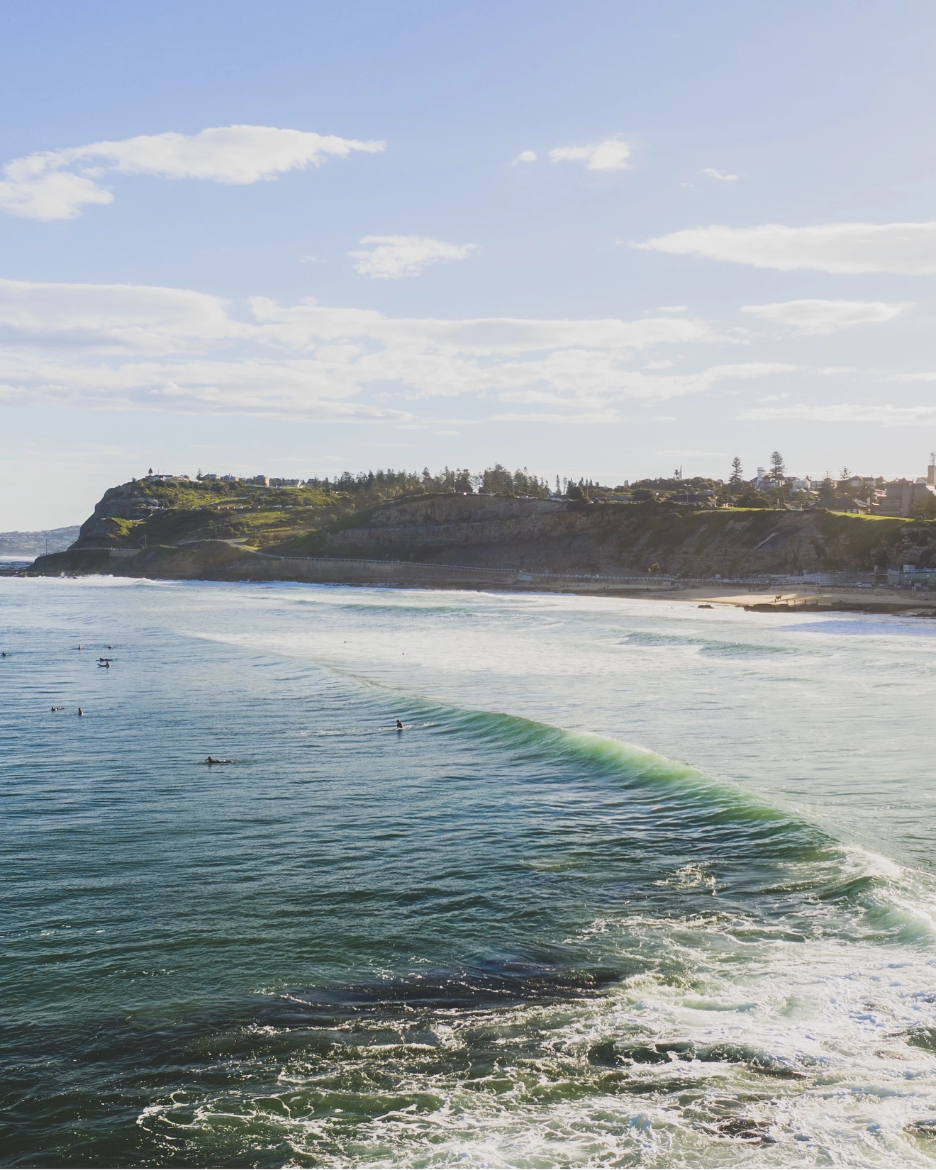 Surfers in the water off Newcastle Beach. Image credit: Destination NSW