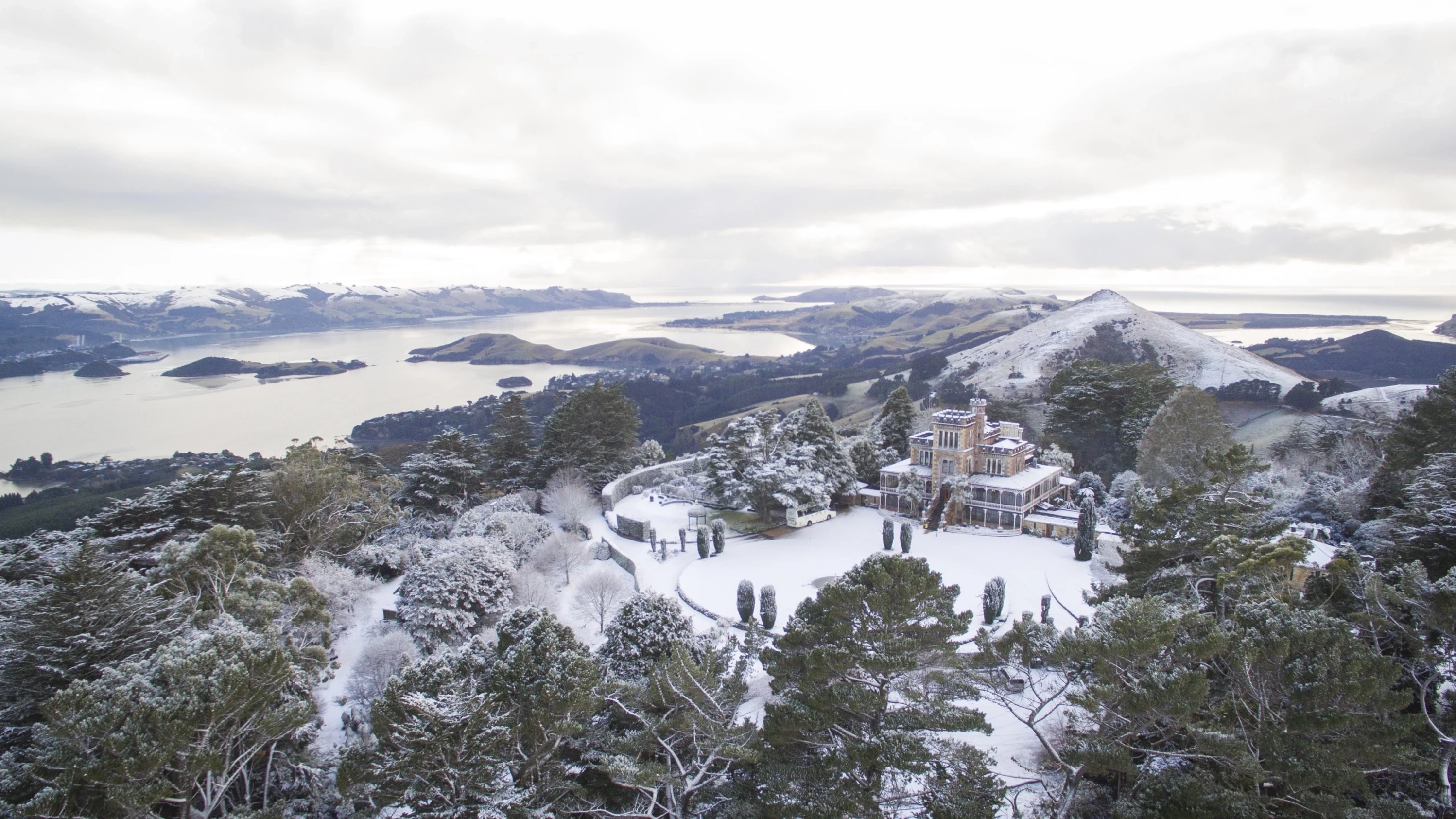 Aerial view of Larnach Castle covered in snow, Dunedin, New Zealand. Image credit: Dunedin NZ