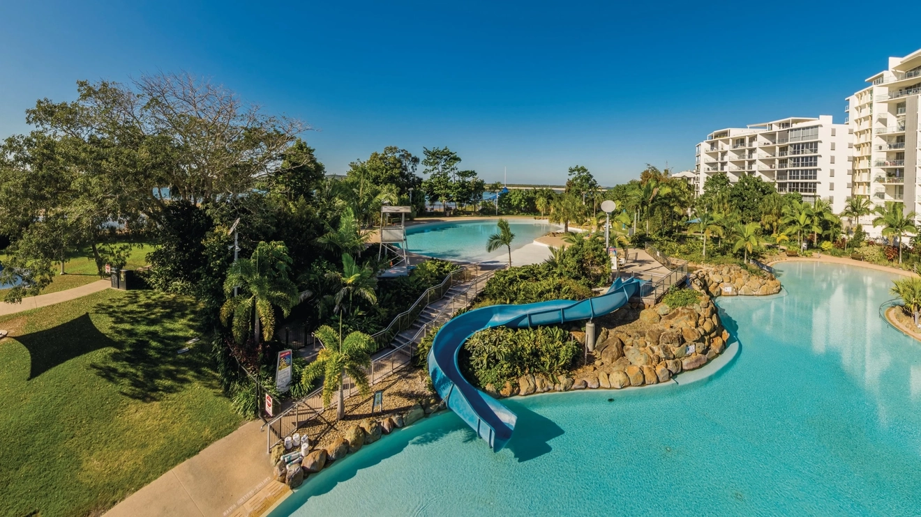 Aerial view of Bluewater Lagoon with high-rise buildings in the background, Mackay. Image credit: Aaron Spence/Tourism and Events Queensland
