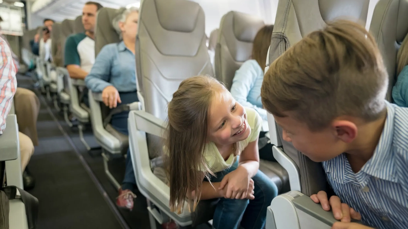 Happy children traveling by plane.