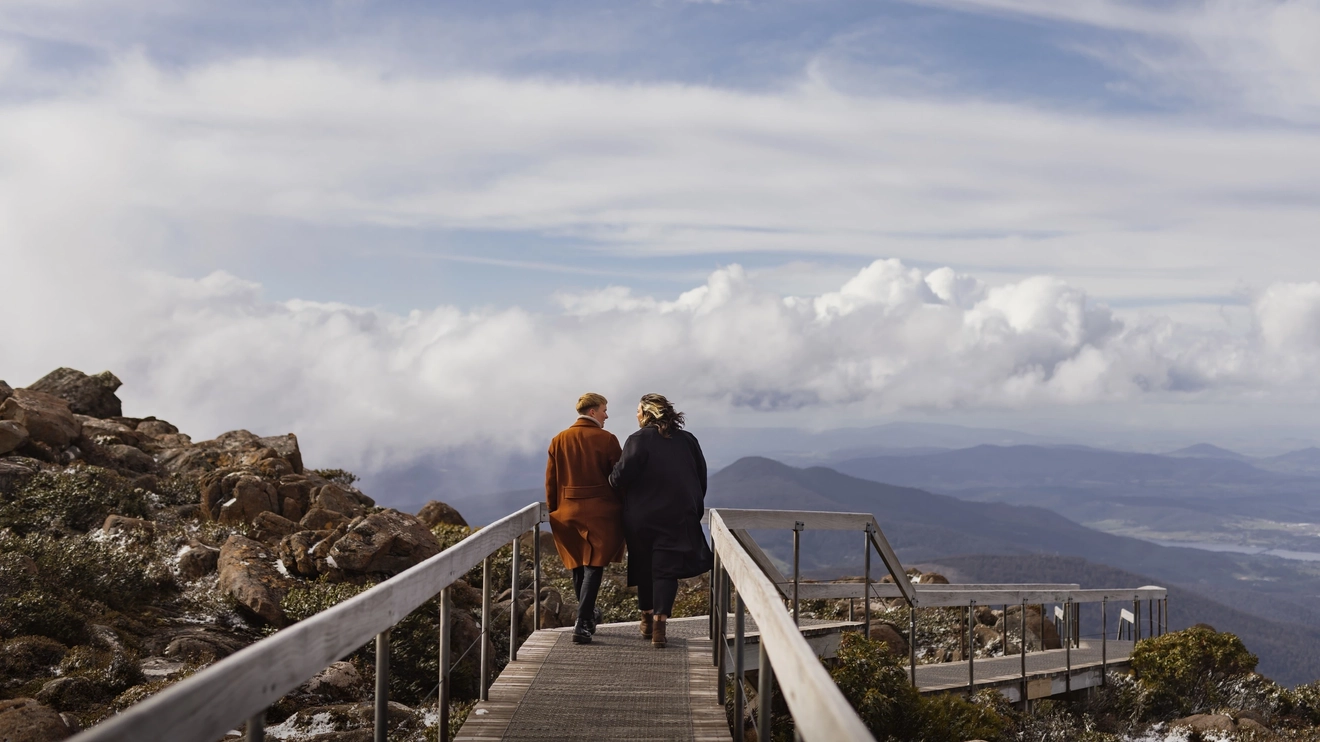 Couple strolling along boardwalk towards lookout at kunanyi/Mount Wellington, Hobart.