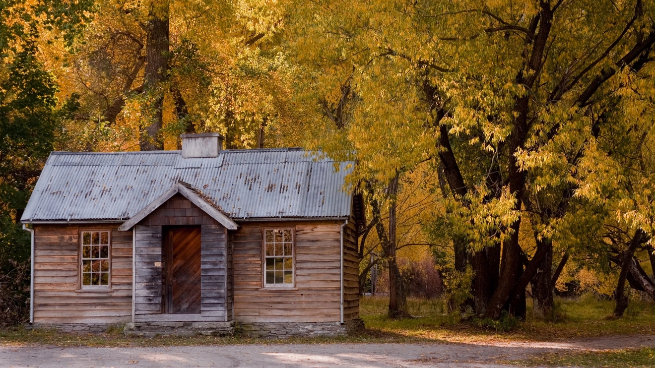 External view of the Police Camp historical cottage surrounded by trees and autumn foliage, Arrowtown, New Zealand. Image credit: Destination Queenstown