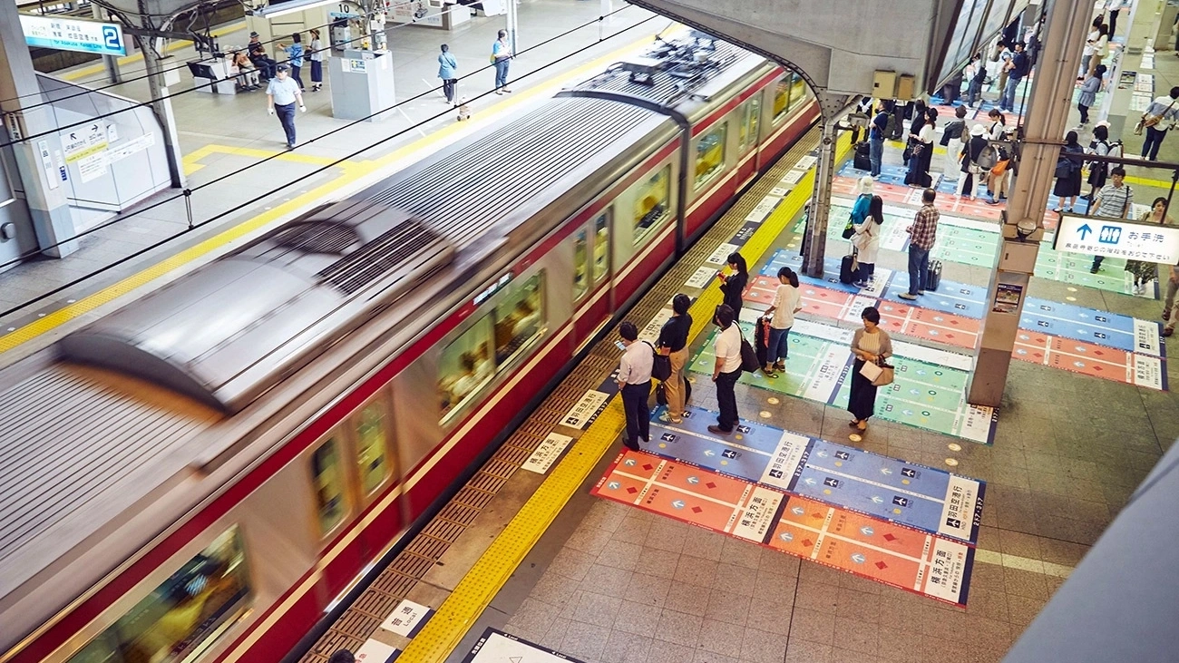 Commuters wait for a train in Tokyo, Japan