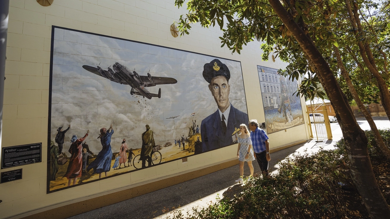 A large wall mural in Maryborough depicts a WWII aircraft and RAAF Squadron Leader Frank Lawrence. Image credit: Tourism and Events Queensland.