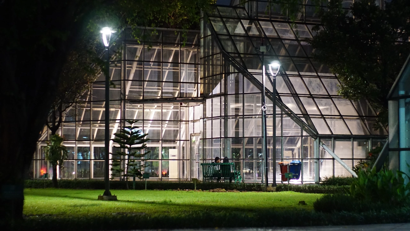 A nighttime view of an illuminated glass greenhouse in Taman Menteng, Jakarta. Image credit: stock.adobe.com