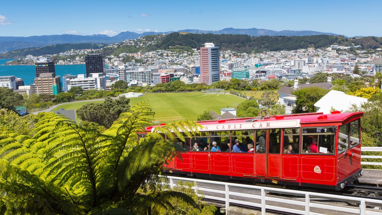 Red Wellington Cable Car travelling up towards the lookout, with Wellington in the background, New Zealand. Image credit: stock.adobe.com
