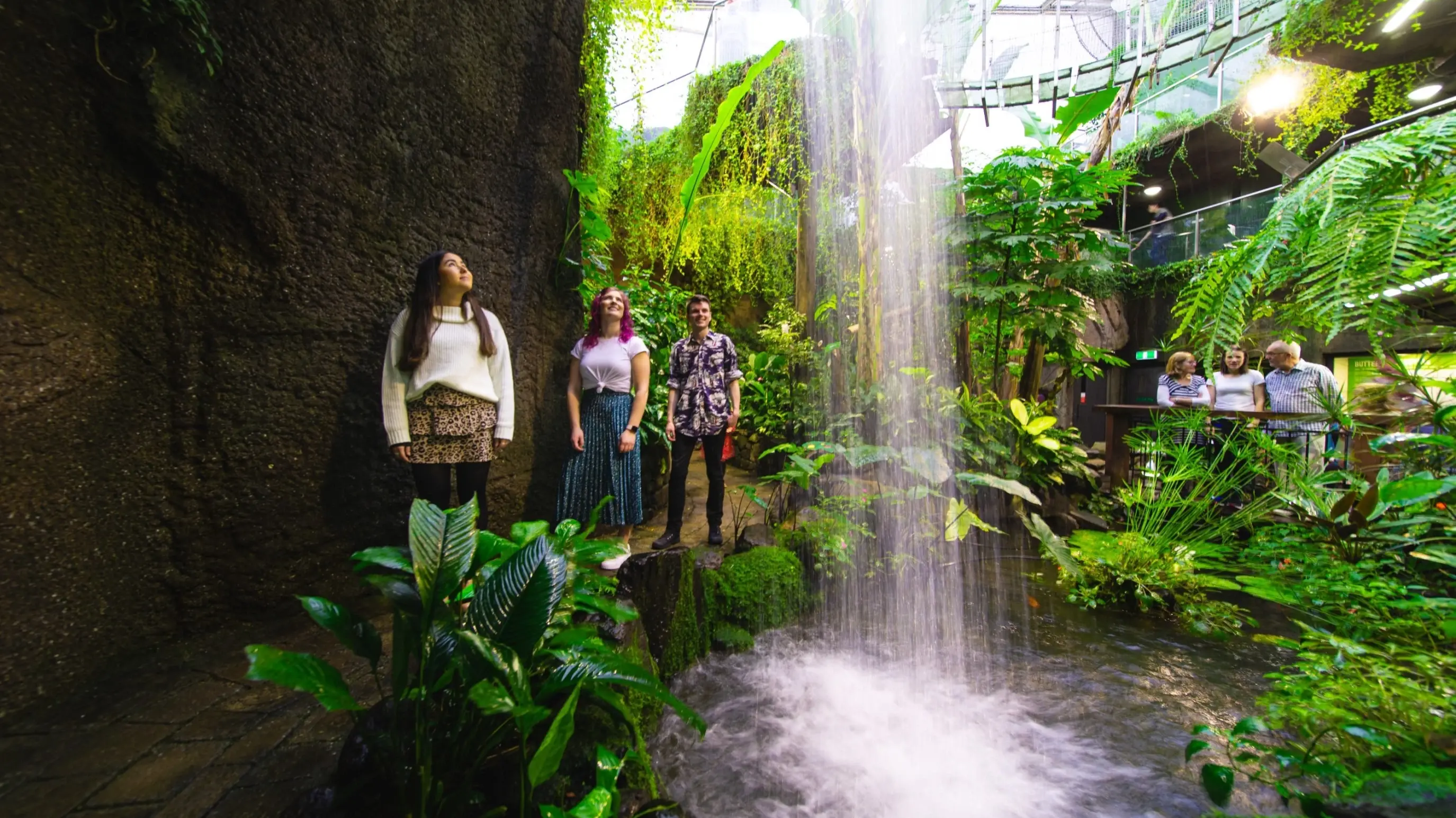 A group of people admire an indoor waterfall flowing into a pool at Otago Museum, Dunedin, New Zealand. Image credit: Dunedin NZ