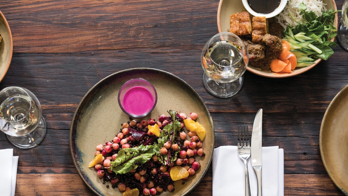 Overhead view of dinner table with plated food and wine glasses, National Wine Centre of Australia, Adelaide, South Australia. Image credit: South Australian Tourism Commission