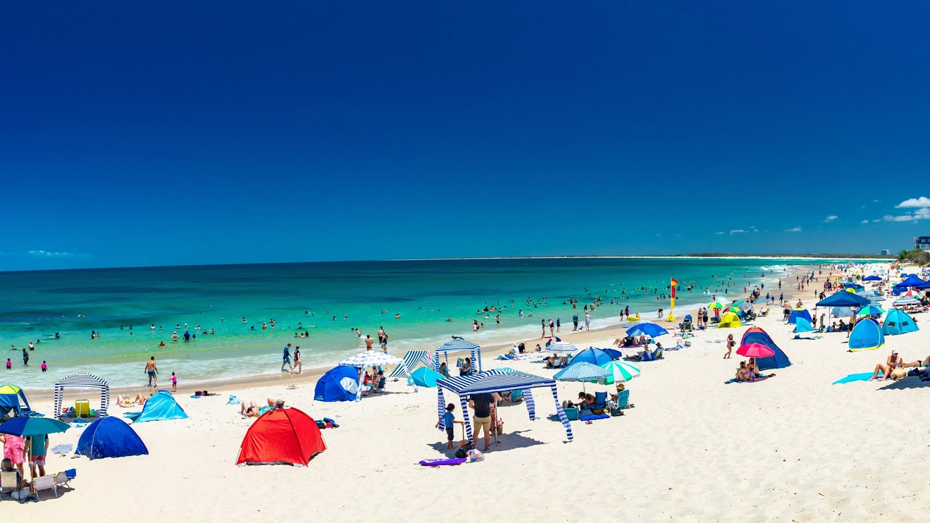 People on the sand and in the water on a hot, sunny day at Kings Beach Calundra, Sunshine Coast, Queensland, Australia. Image credit: Martin Valigursky/Shutterstock.com