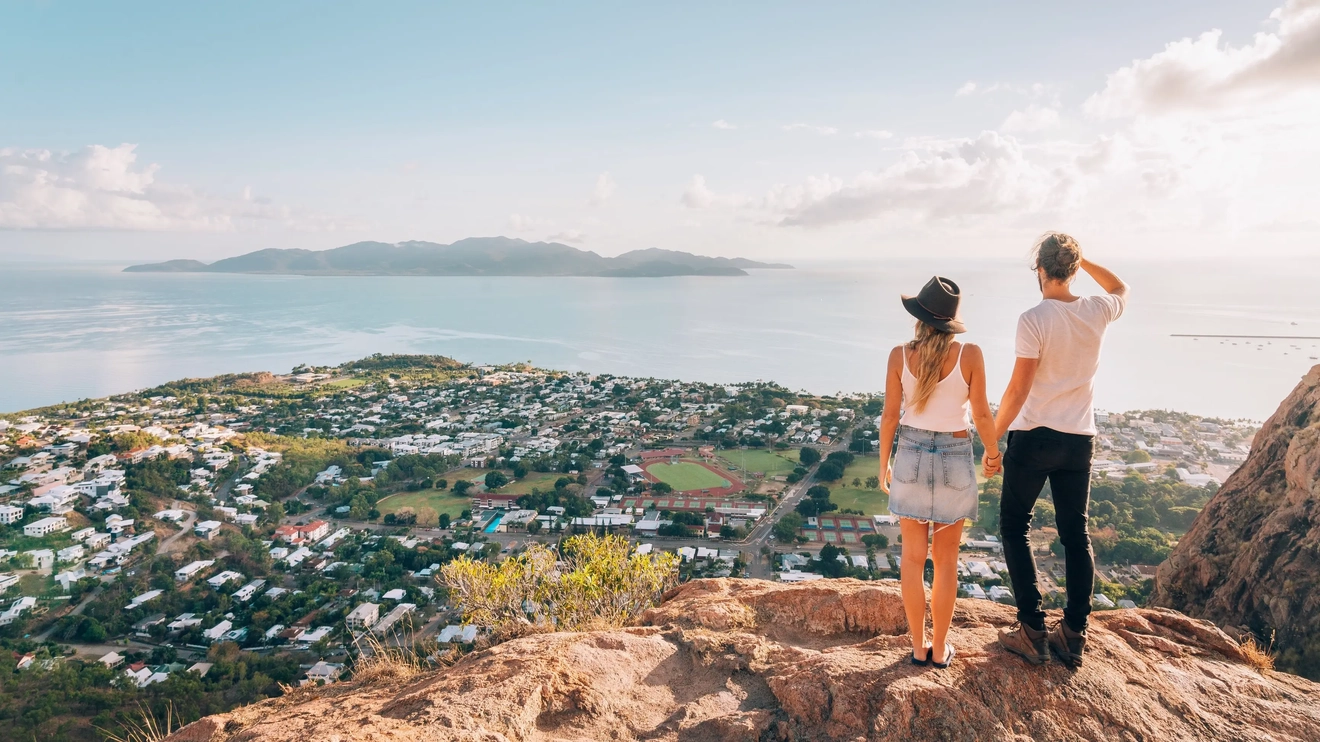 Back view of a couple admiring the view of Townsville and Magnetic Island from Castle Rock. Image credit: Tourism and Events Queensland