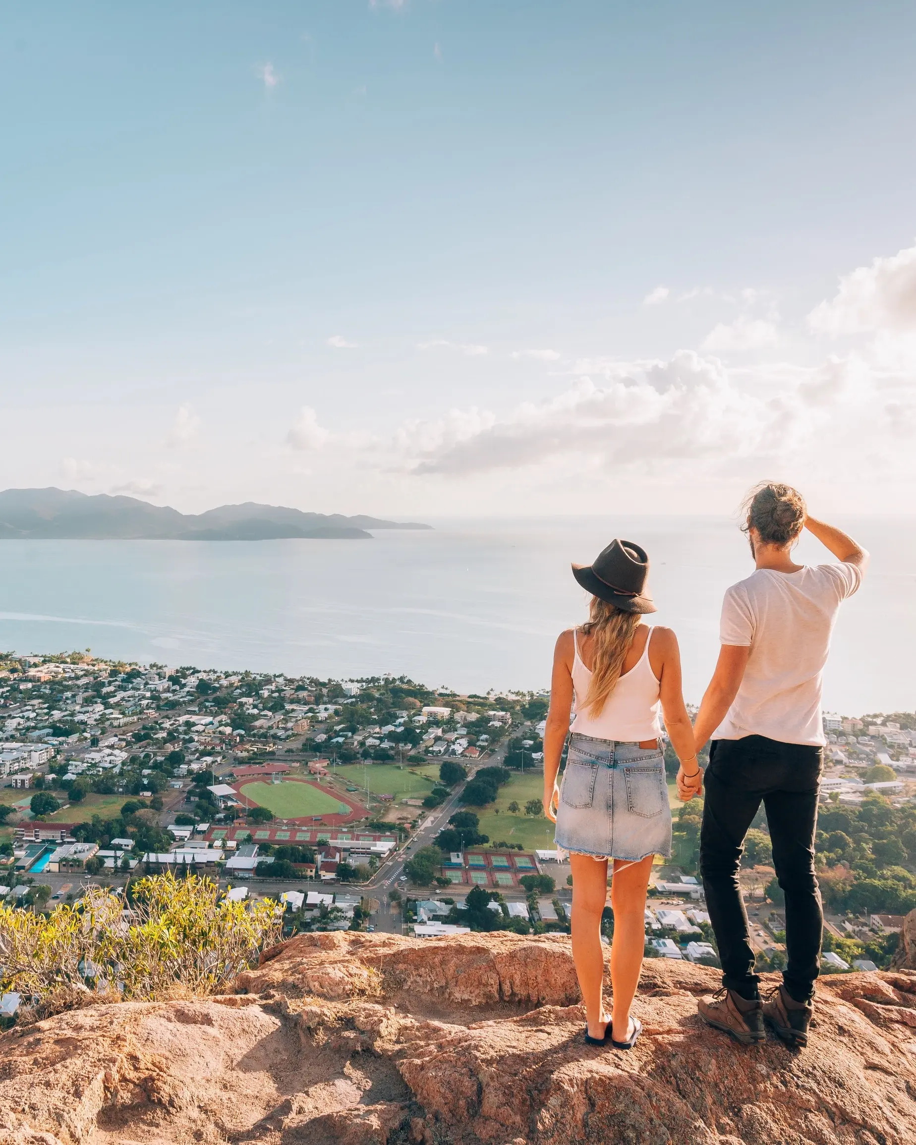 Back view of a couple admiring the view of Townsville and Magnetic Island from Castle Rock. Image credit: Tourism and Events Queensland